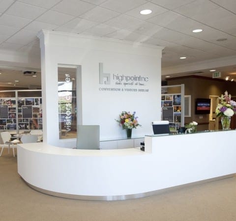High Point, NC, Visitors Center custom fabricated and installed entrance reception desk and wall partition with 3D logo